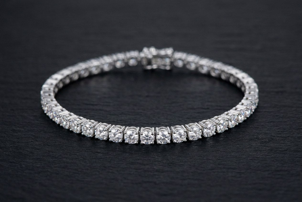 A 4mm round-cut moissanite tennis bracelet in polished .925 sterling silver curved on a dark stone surface