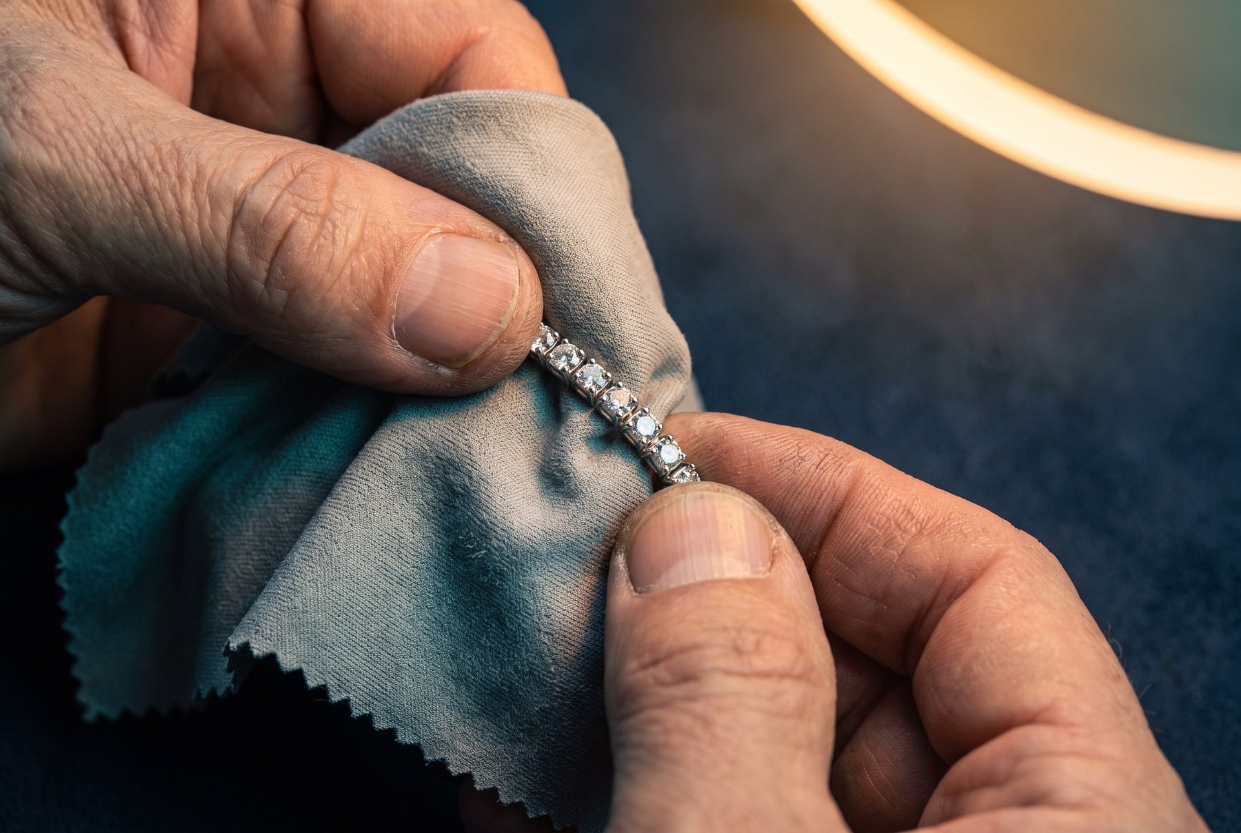 A sterling silver piece being cleaned with a polishing cloth