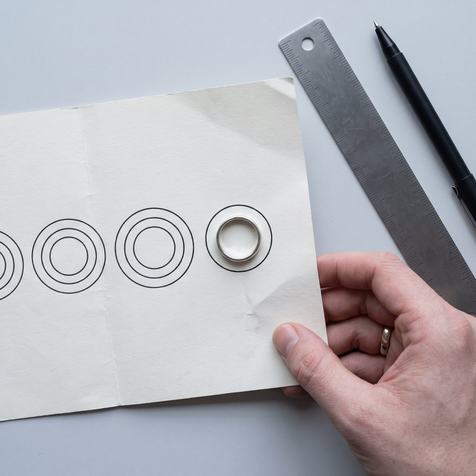Step two of finding your ring size: measuring that ring's inside diameter against the size guide