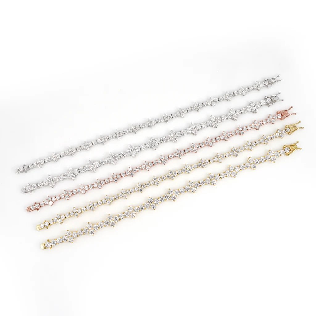 Four elegant tennis bracelets are displayed side by side in silver, rose gold, and yellow gold, including the sparkling 'True Hive' Patterned Design Bracelet in sterling silver with a hexagonal motif—all on a white background.