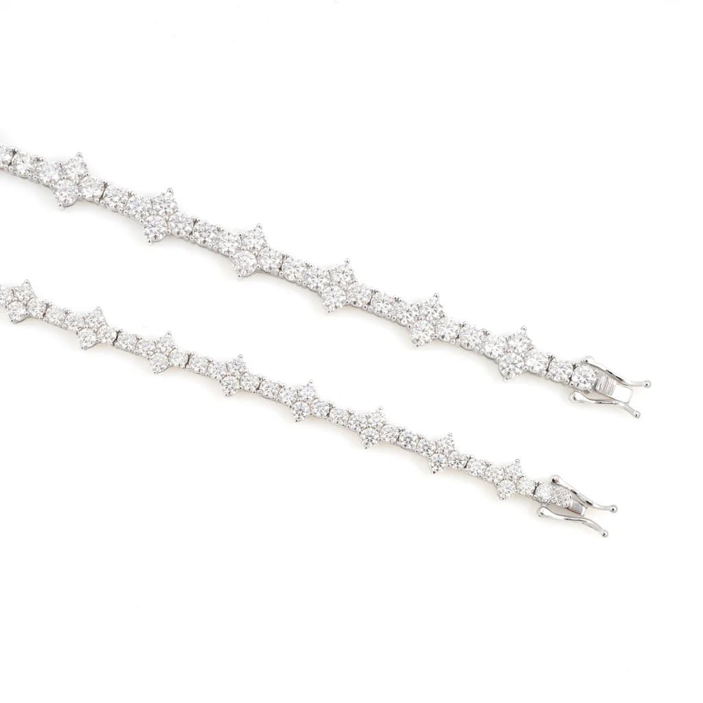 Two moissanite tennis bracelets in silver and white-gold tone with star-shaped links on a white background