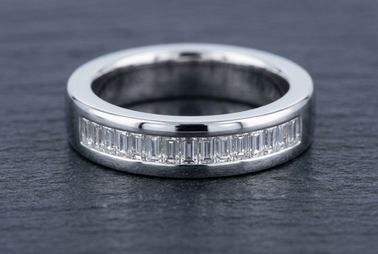 Row of baguette cut moissanite stones channel set along a polished sterling silver band