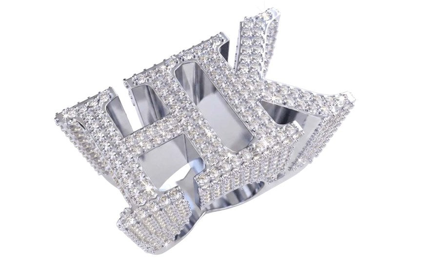 The Custom 'HK' Championship Pinky Ring by Jamilah Jewels features a bold silver design, sparkling diamonds, and uppercase H and K letters for a standout look.