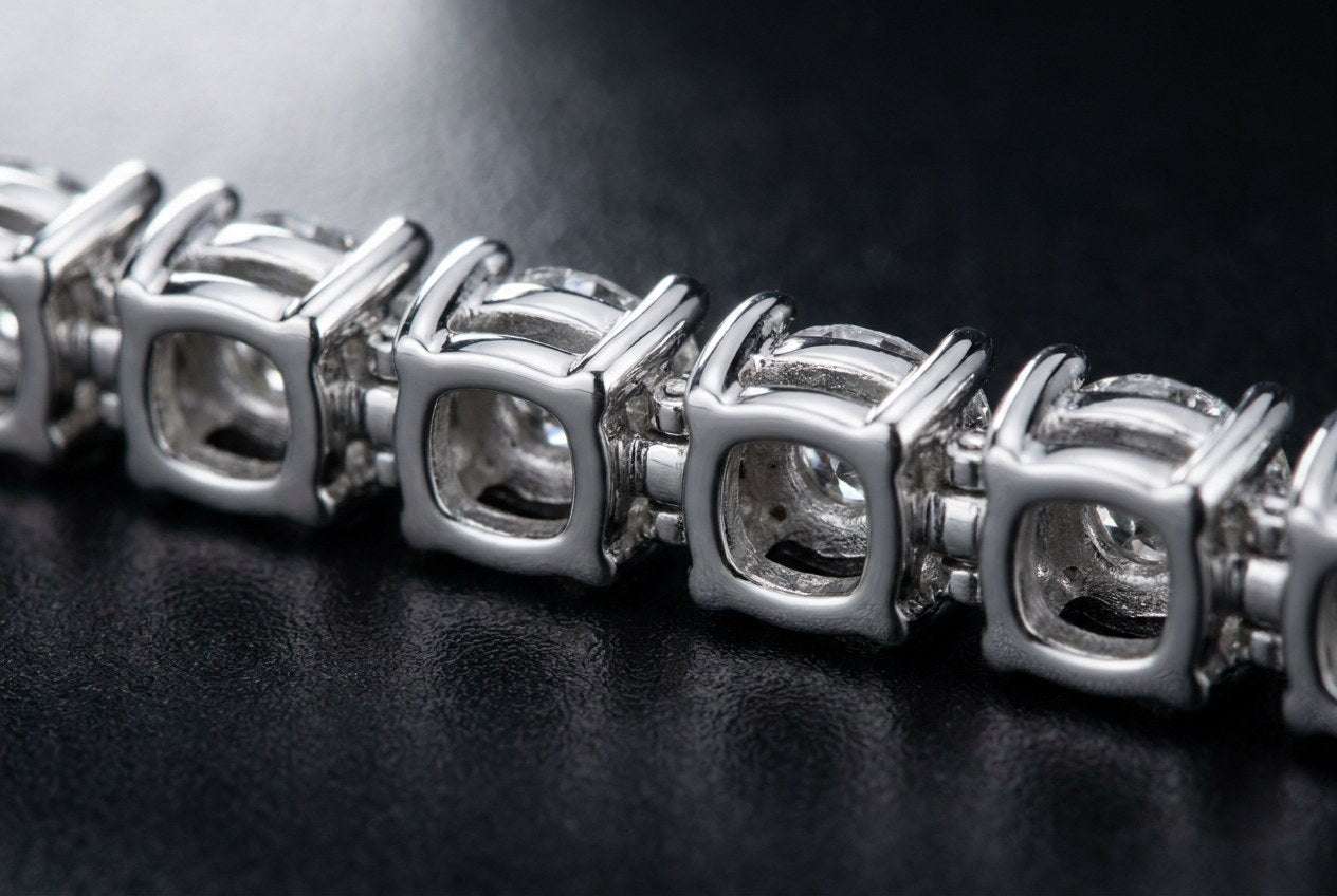 Side view of a tennis chain showing each stone in its own four prong setting with open backs and hinged links between them
