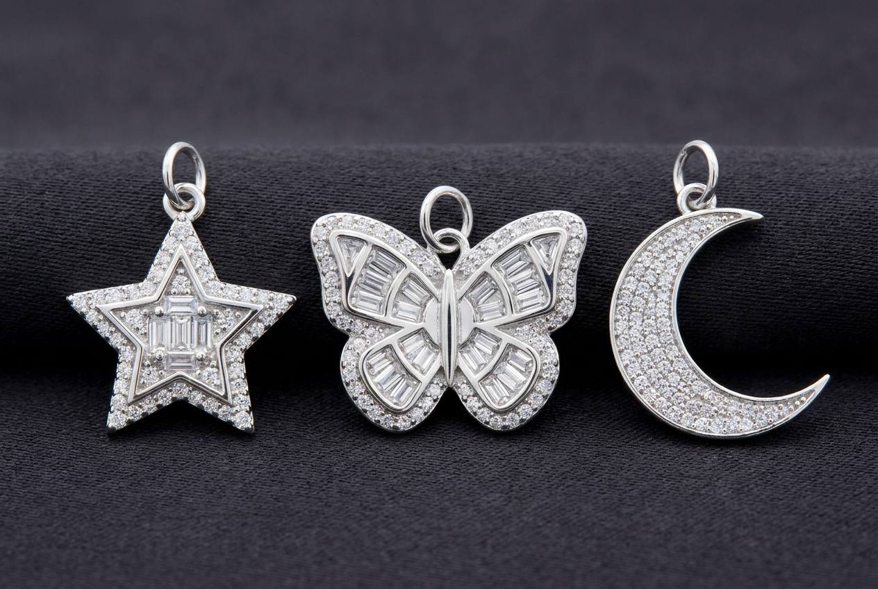 Three sterling silver moissanite pendants side by side, a star, a butterfly and a crescent moon