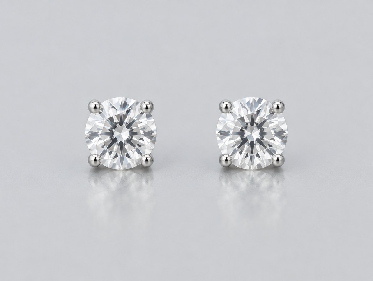 Two round brilliant-cut colorless stud earrings side by side on a grey surface for visual comparison