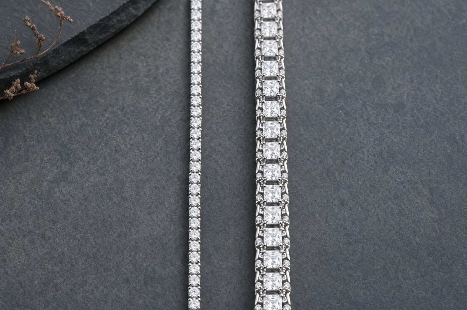 Slim 4mm moissanite tennis chain laid beside a wider statement tennis chain to compare widths