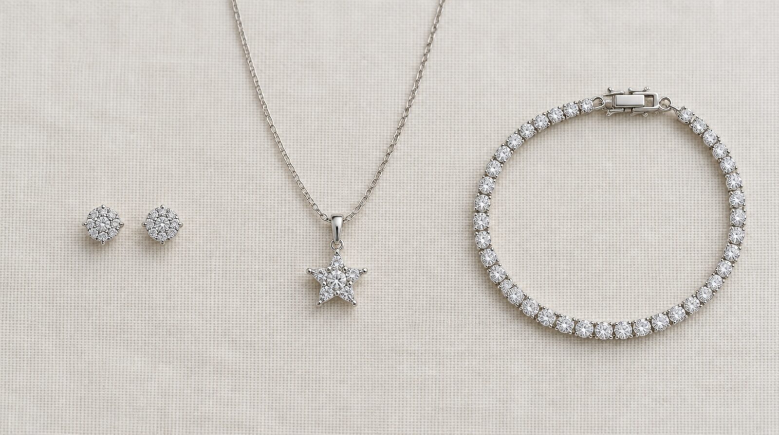 Flat lay of stud earrings, a star pendant on a chain and a tennis bracelet, the three jewelry gifts that need no size