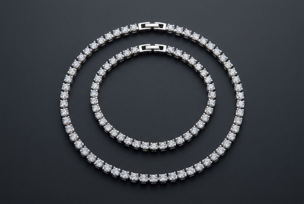 Two sterling silver stone-set chains laid side by side at different lengths on a dark surface, showing the gap between layering lengths