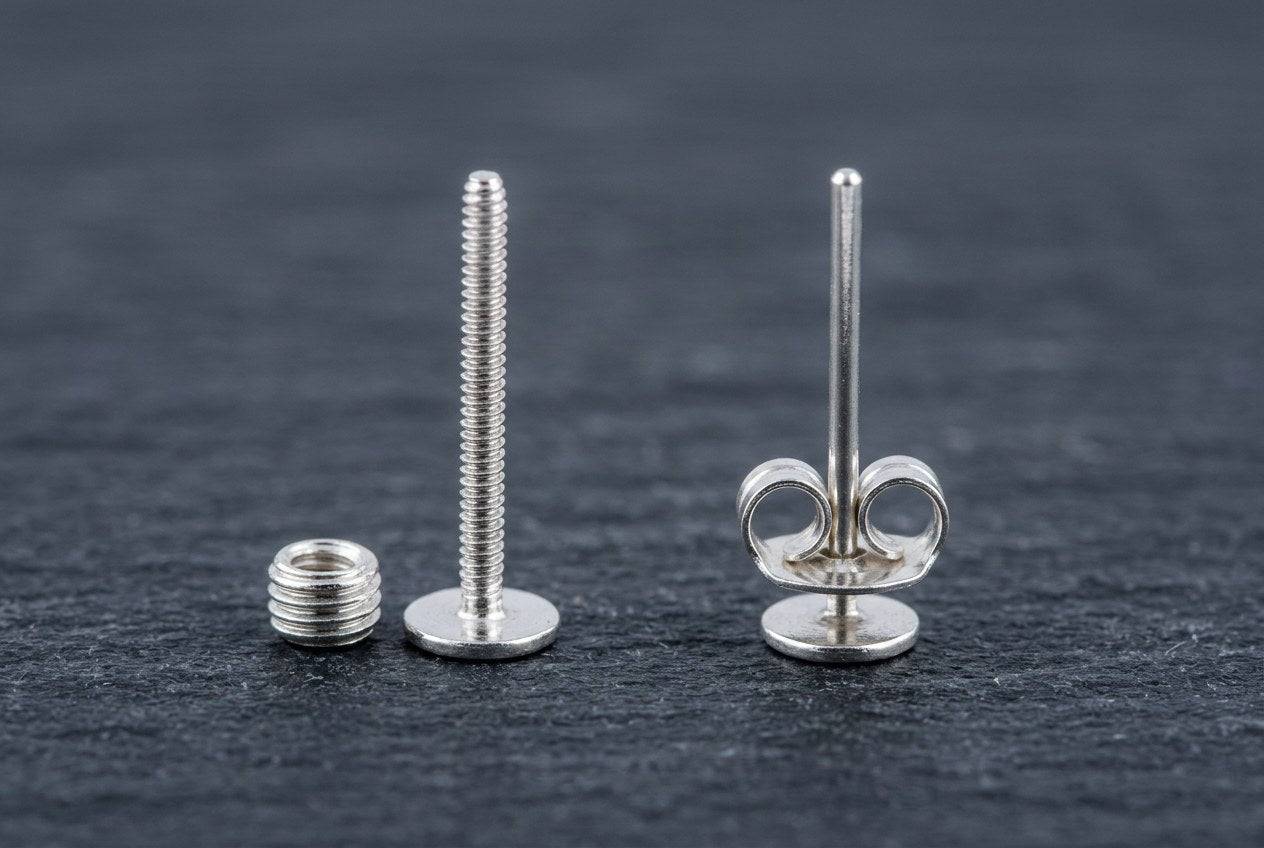 A threaded screw-back earring post and nut next to a smooth push-back post with a butterfly friction back