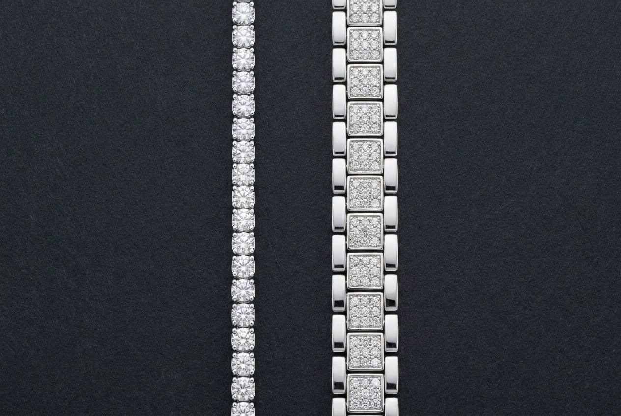 A narrow single row tennis chain beside a wider clustered chain whose links each hold a group of small stones