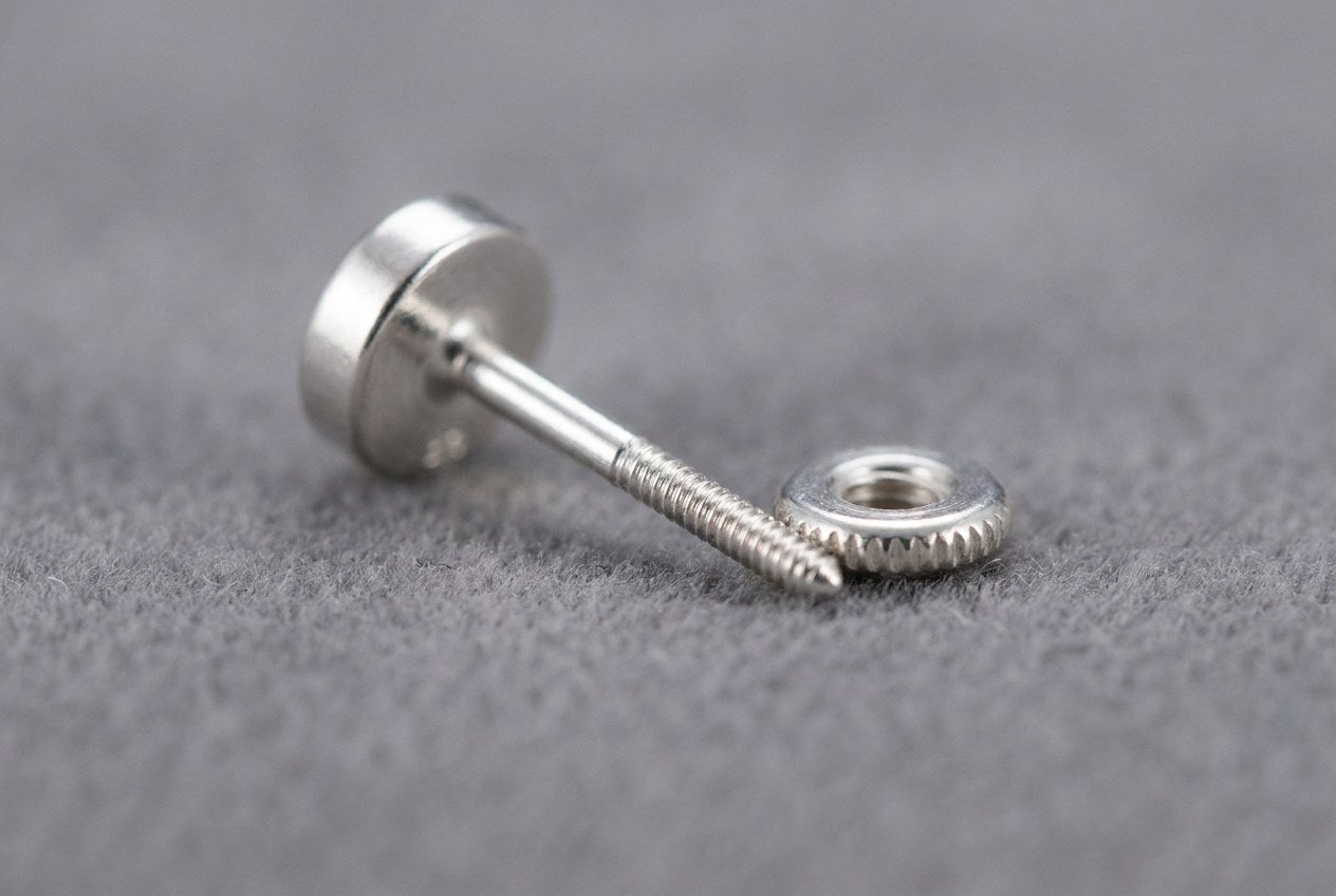 Close-up of a solid sterling silver earring post and matching screw back