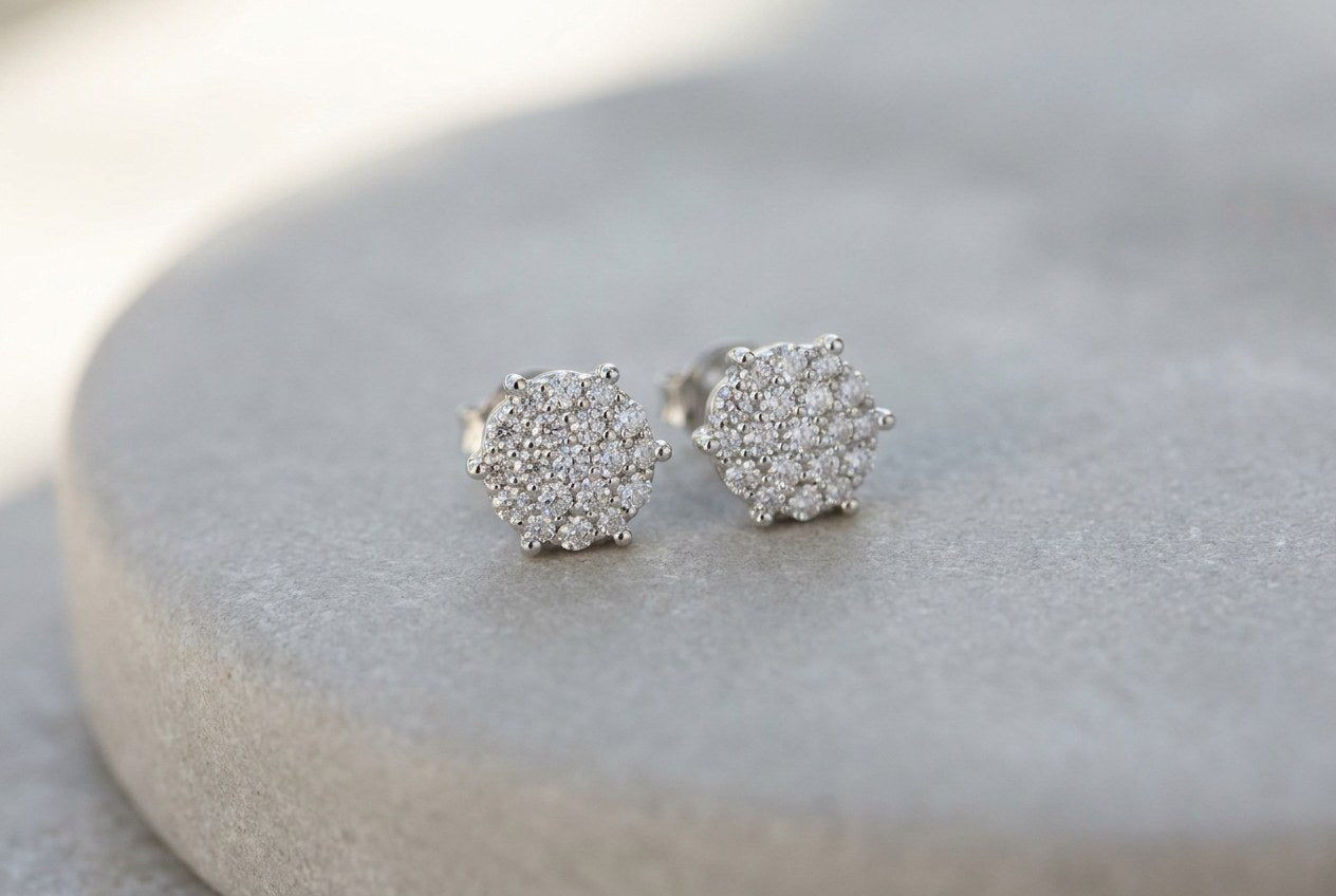 Pair of moissanite cluster stud earrings in sterling silver on a neutral surface