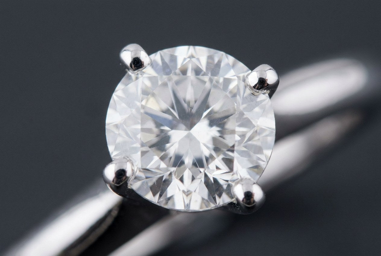 Close-up of four silver prongs curving over the edge of a clear round stone