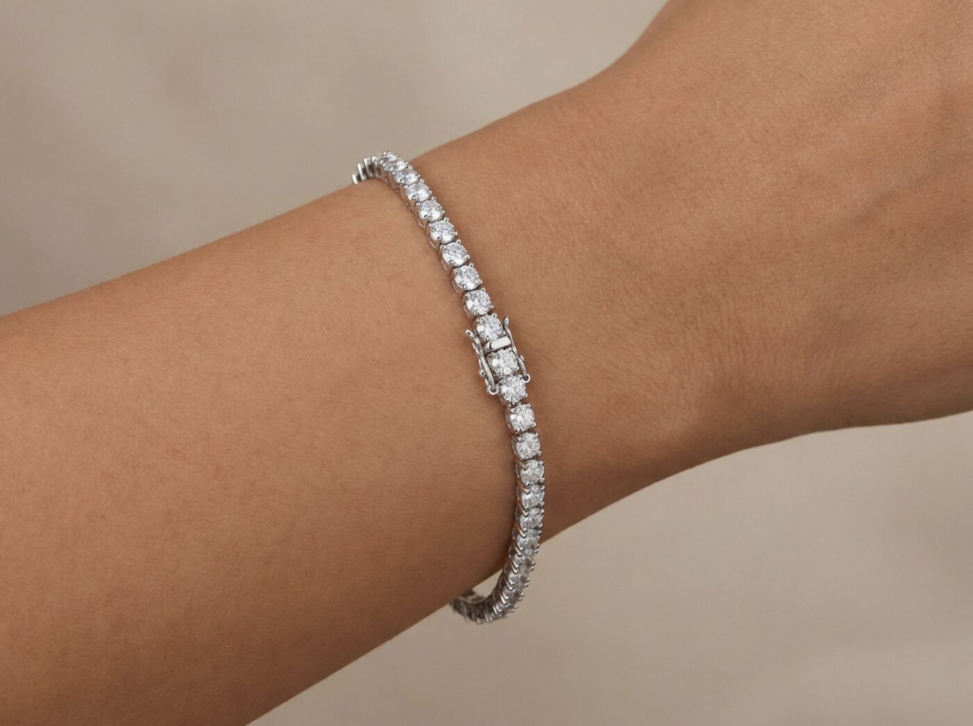 Slim sterling silver moissanite tennis bracelet fastened on a wrist showing how much slack a good fit leaves