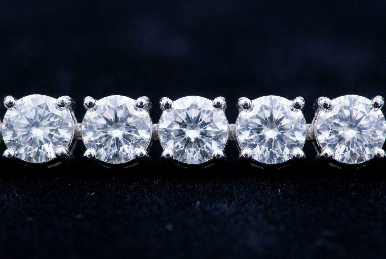 Macro view of five round moissanite stones in a row, each cut and set to match its neighbors