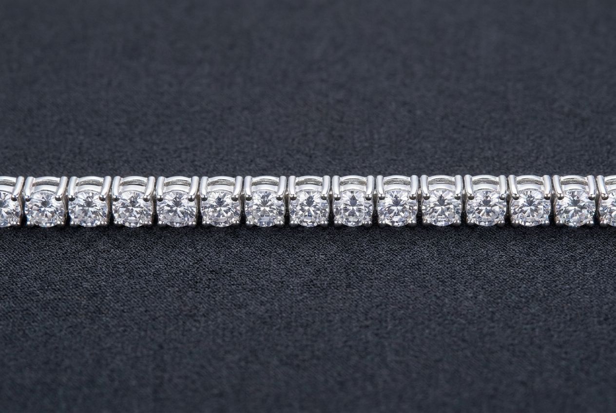 Close view of a sterling silver tennis bracelet showing an even row of matched round moissanite stones